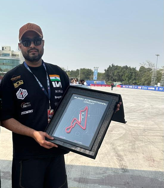 f10dalal holding a framed certificate outdoors with a clear sky background